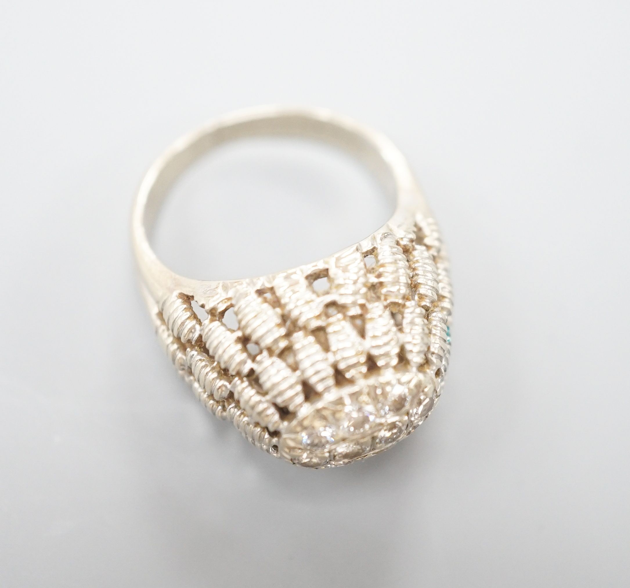 A continental textured white metal and diamond cluster set domed top dress ring, size K/L, gross weight 5.5 grams.